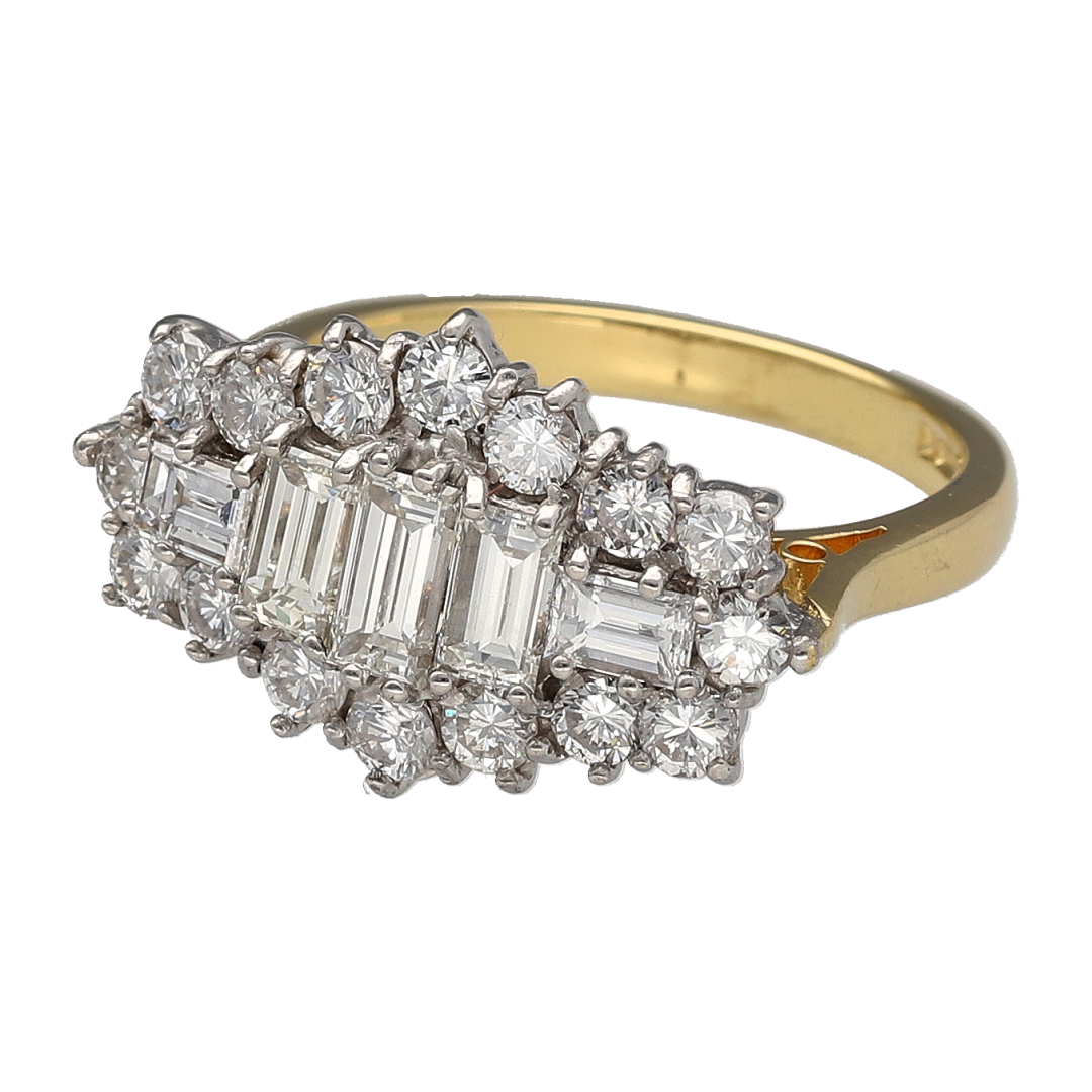 Add luxurious sparkle and timeless elegance to your jewellery collection with this pre-owned 18ct yellow gold diamond set cluster ring—an eye-catching statement piece perfect for special occasions.

Design: This ring features a striking boat-shaped cluster, set with sixteen brilliant-cut and five baguette-cut diamonds, creating a beautifully layered and dynamic look across the finger.