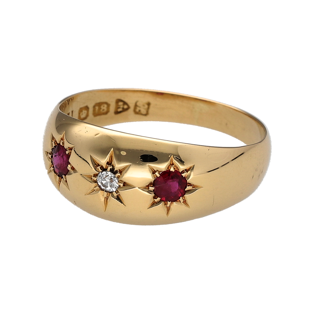 Add vintage charm and elegant colour to your collection with this pre-owned 18ct yellow gold diamond and ruby set trilogy band ring—an eye-catching piece with timeless appeal.

Design: The ring features a wide 9mm front, set in a vintage-inspired trilogy style with a central sparkling diamond flanked by two round rubies, each approximately 3mm in diameter, creating a beautifully balanced and distinctive look.