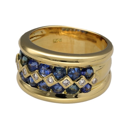 Make a bold statement with this pre-owned 18ct yellow gold diamond and sapphire wide band ring. Featuring a luxurious multi-row design with rich blue sapphires and sparkling diamonds, this substantial ring combines timeless elegance with exceptional presence.

Design: The ring showcases an impressive 13mm wide front, featuring two rows of vibrant blue sapphires with a row of sparkling diamonds running through the centre.