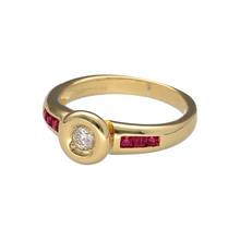Load image into Gallery viewer, Add luxurious colour and refined sparkle to your collection with this pre-owned 18ct yellow gold diamond and ruby set ring—a timeless piece that combines rich hues with elegant design, perfect for special occasions or as a standout everyday statement.

Design: This ring features a central rubover set diamond of approximately 0.15ct, accented by vibrant rubies set along the shoulders to create a striking and sophisticated look.

