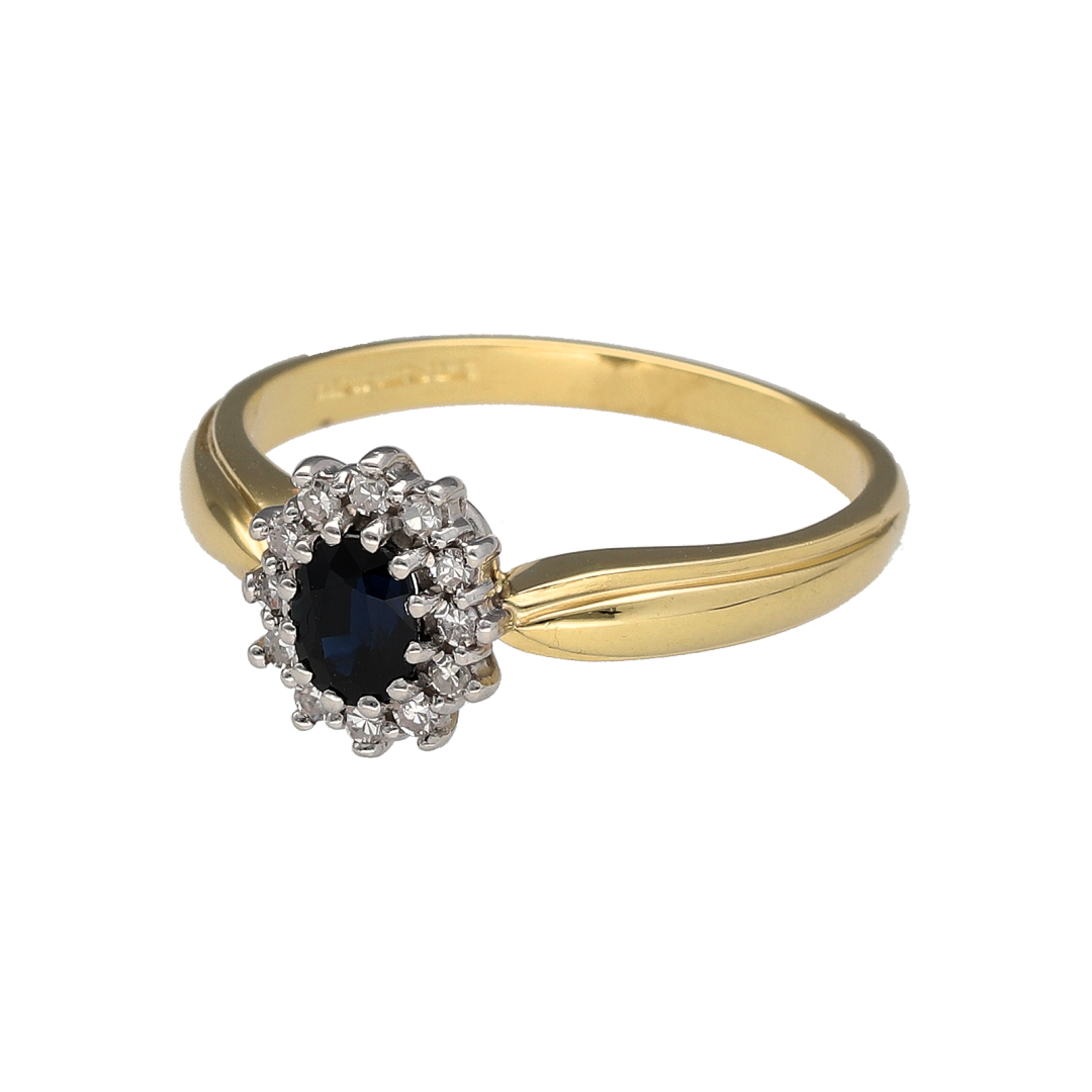 Add timeless elegance and deep colour to your collection with this pre-owned 18ct yellow gold diamond and sapphire cluster ring, blending classic design with refined sparkle—perfect for special occasions or sophisticated everyday wear.

Design: The ring features a 5mm by 4mm oval-cut sapphire at the centre, surrounded by a halo of brilliant-cut diamonds that enhance the rich blue tones of the gemstone.