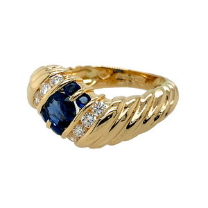 Preowned 18ct Yellow Gold Diamond & Sapphire Set Wave Ring in size L with the weight 5.90 grams. The center sapphire stone is 4mm and the surrounding stones are each 2mm diameter
