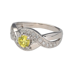 Preowned 18ct White Gold & Diamond Twist Over Set Ring in size N with the weight 5.40 grams. The center Diamond is yellow and is approximately 36pt - 40pt. The yellow Diamond is surrounded by smaller white Diamonds which go onto the shoulders